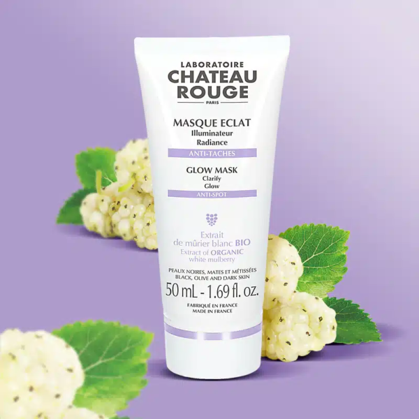 Un tube de Chateau Rouge Masque Glow au Mûrier blanc Bio ILLUMINATEUR 50 ml avec des mûres blanches et des feuilles en fond sur une surface violette. dakar