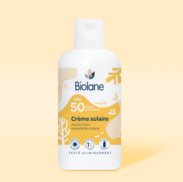 Un flacon de BIOLANE Crème Solaire Bébé SPF 50 125 ml aux propriétés respectueuses de l'océan et résistantes à l'eau se trouve sur un fond jaune clair