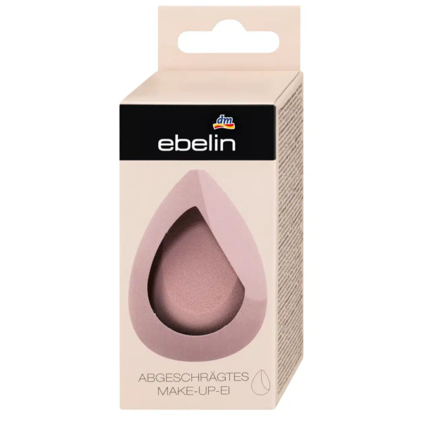 Une boîte beige avec une fenêtre en forme de goutte d'eau présente une éponge à maquillage rose, évoquant les marchés animés de Dakar. L'emballage affiche en évidence la marque « ebelin », avec le texte allemand « Abgeschrägtes Make-up Ei », et est surmonté d'un petit logo « dm », alliant le style sénégalais à un savoir-faire méticuleux. Dakar