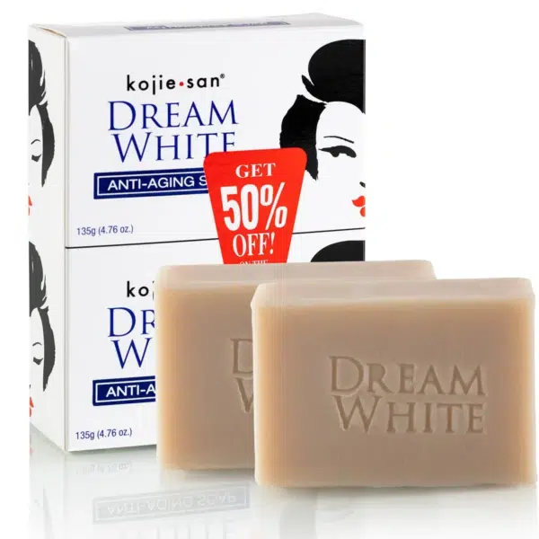 Deux barres de savon Kojie San Savon Éclat Anti Age Dream White sont présentées devant leur emballage étiqueté « Kojie San Savon Éclat Anti Age Dream White 2 x 135 g »