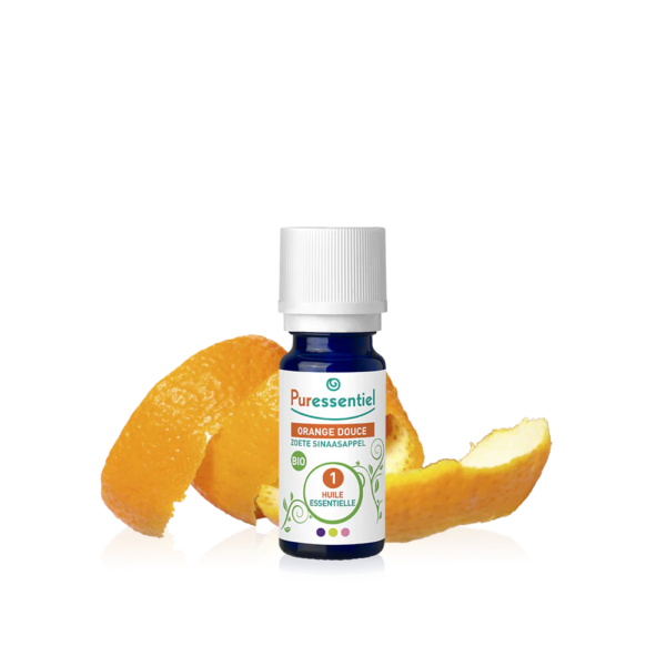 Un petit flacon étiqueté « Puressentiel Huile Essentielle Orange Douce BIO 10 ml » se dresse élégamment avec des écorces d'orange en arrière-plan