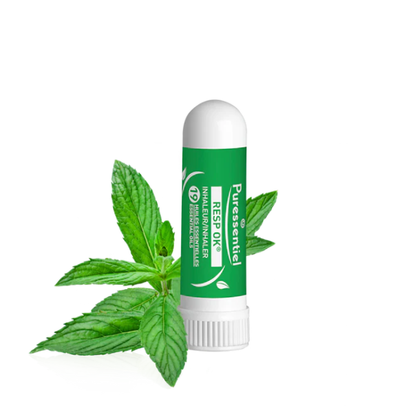 Un Puressentiel Inhaleur Respiratoire 1 ml de couleur verte est placé à côté de feuilles de menthe sur un fond blanc épuré. dakar