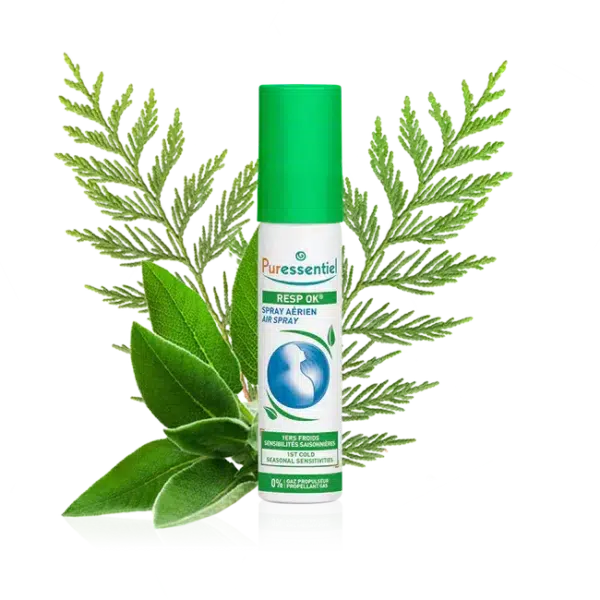 Un flacon de PURESSENTIEL Spray Aérien Resp'OK 20 ml avec en arrière plan un feuillage vert et des herbes.