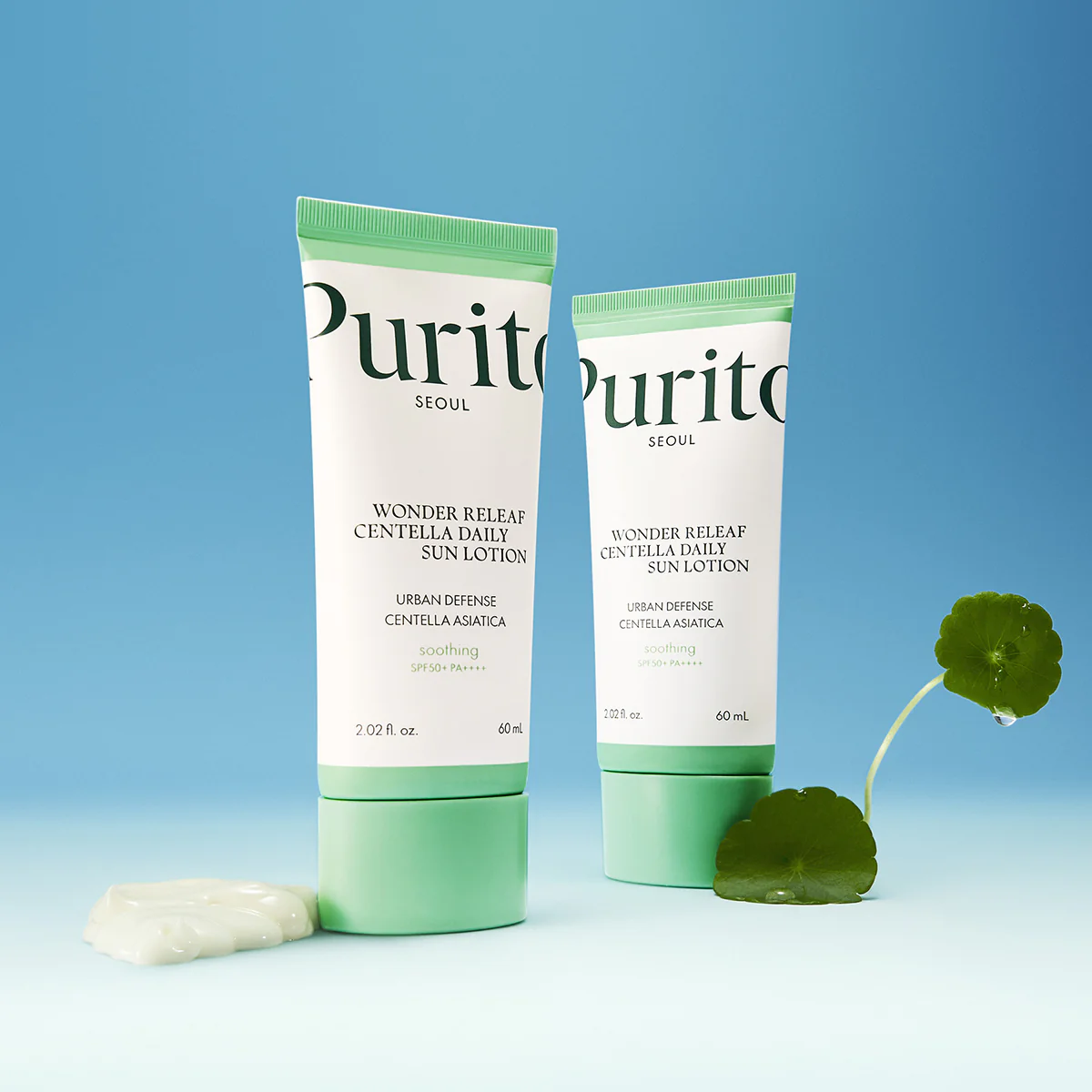 Deux tubes de Purito SÉOUL Lotion Solaire Quotidienne Spf50 Wonder Releaf Centella Peau Sensibles 60 ml se tiennent debout avec une petite feuille et une noisette de lotion devant un fond bleu. dakar