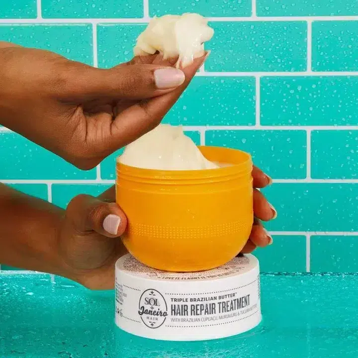 Un pot ouvert de Sol de Janeiro Brazil Bum Bum Cream crème raffermissante et lissante fesses et hanches 75 ml avec de la crème renversée sur le fond jaune vif